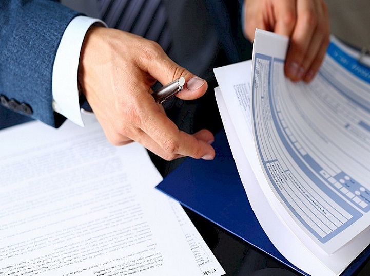 Male arm in suit offer insurance form clipped to pad and silver pen to sign closeup. Strike a bargain, driver money loss prevention, secure road trip, harmless drive idea, owner protective concept